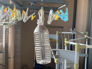 洗濯竿に角型·丸型ハンガーをぶら下げ、その洗濯バサミにペットボトルを挟み天日干しにする